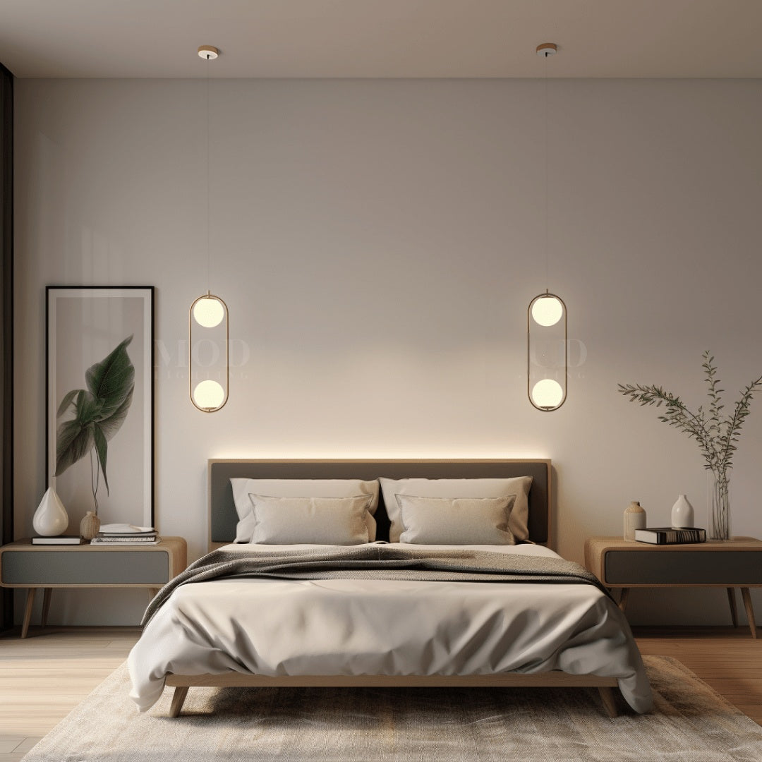 Brushed gold double-globe cage pendant lights above a bed