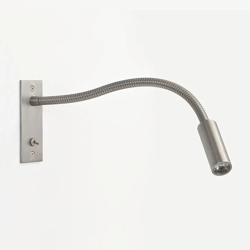 Flexible nickel LED reading wall lamp with a slim adjustable arm and integrated toggle switch, ideal for bedside lighting in a modern bedroom interior.