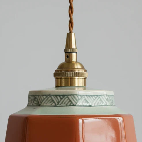 Close-up of red ceramic shade and metal top fitting