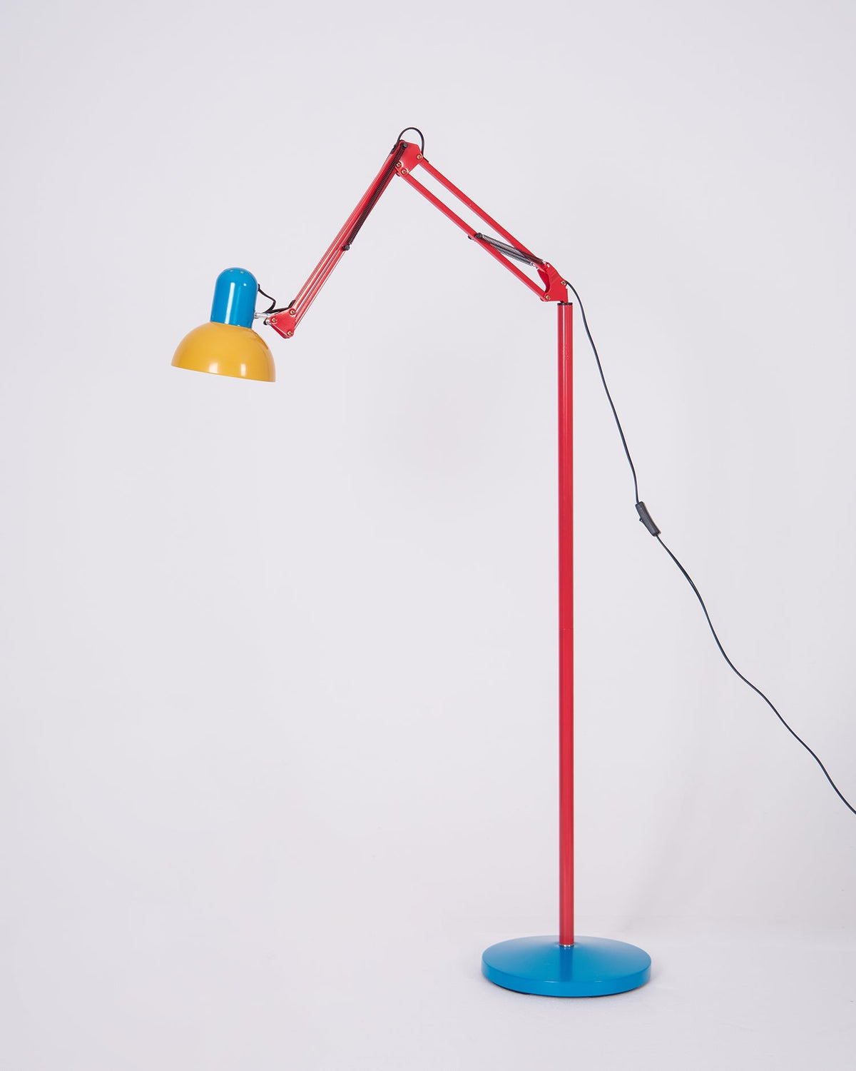 Colourful floor lamp with angled arm and power cable