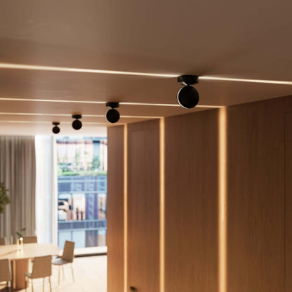 Black adjustable LED ceiling spotlights along a room
