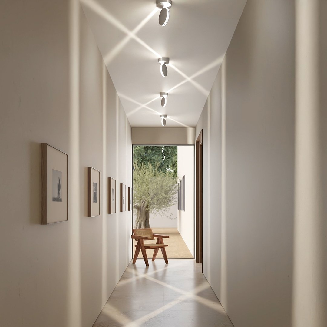 White rotating-disc ceiling spotlight illuminating a hallway