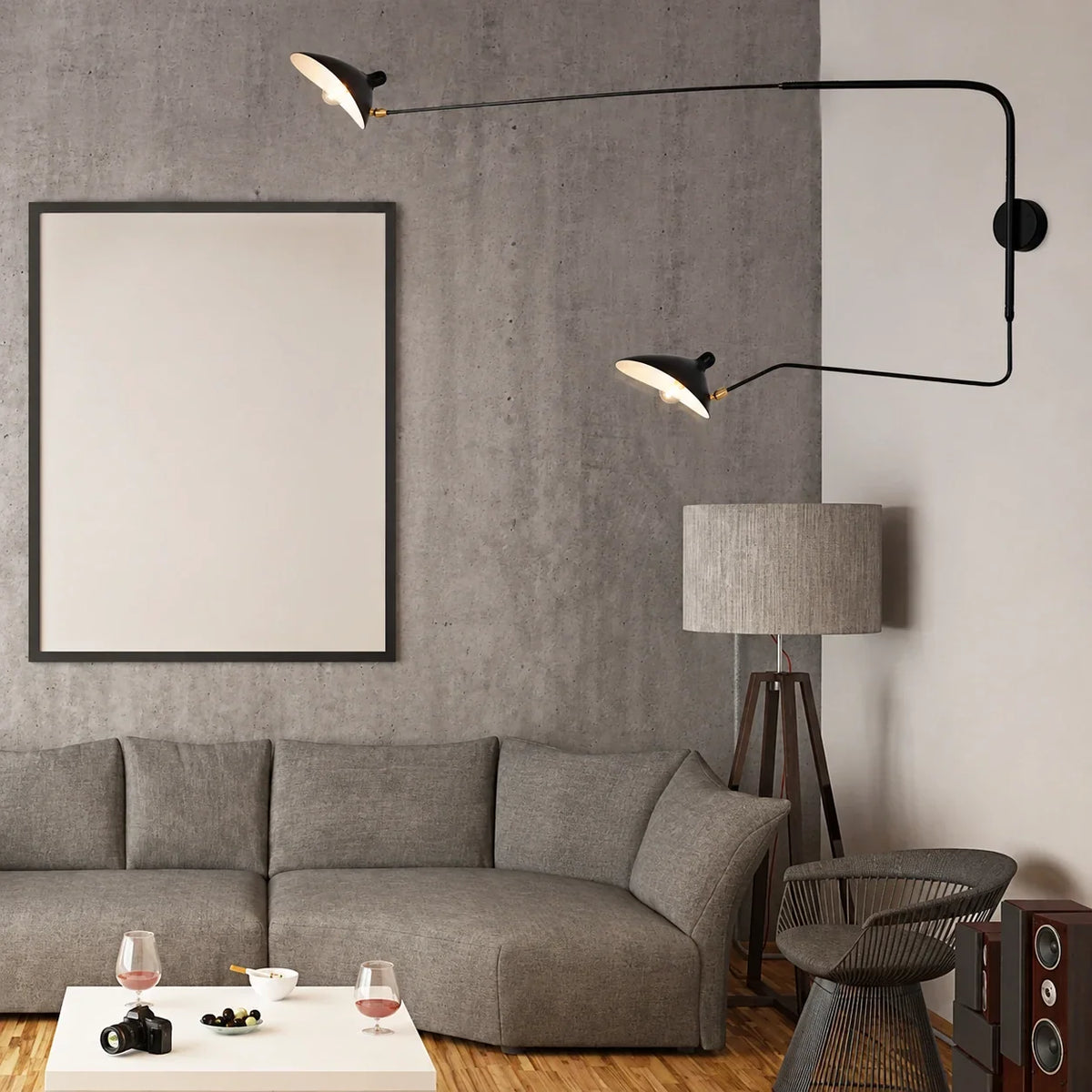 A modern black adjustable swing-arm wall lamp with two lights, mounted in a contemporary living room with a grey sofa and concrete-effect wall.