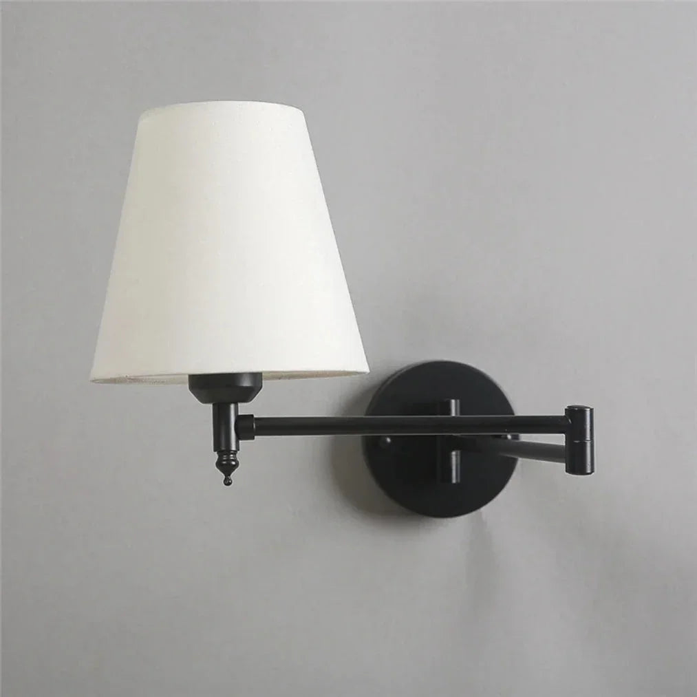 Modern adjustable swing arm wall lamp featuring a black metal fixture and a tapered white fabric shade, mounted on a light grey wall.