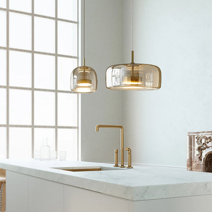 Pair of amber glass dome pendant lights in a kitchen
