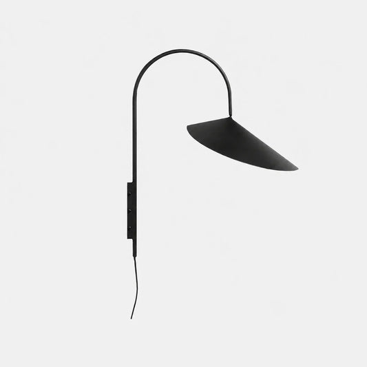 A minimalist black arched metal wall lamp featuring a wide, shallow conical shade and a plug-in cord, set against a clean white background.