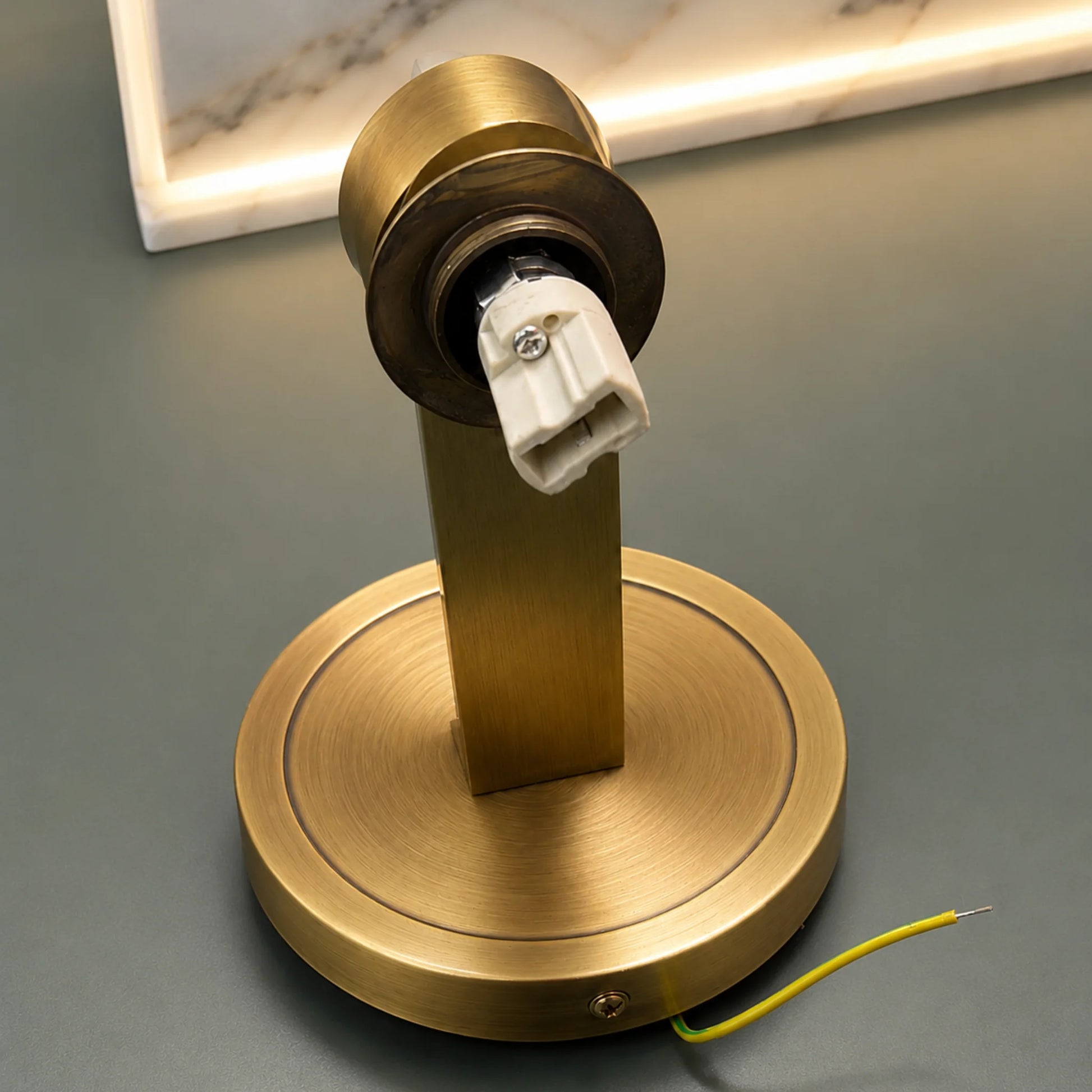 Brushed brass wall light base with a central vertical arm and exposed bulb socket, designed for an Art Deco alabaster ball wall light fixture.