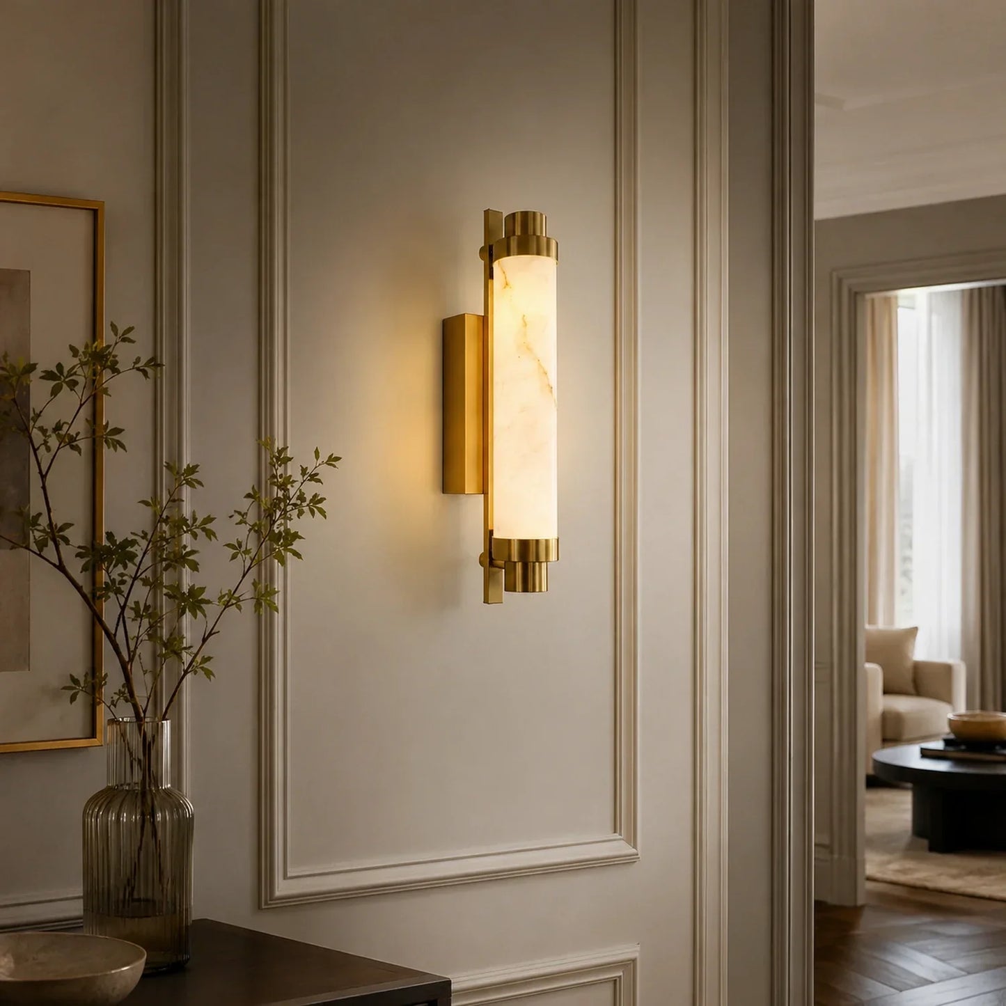 An Art Deco LED wall light with a brass fixture and glowing simulated marble shade, mounted on a classic panelled wall in a stylish home interior.