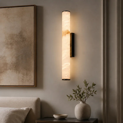 Modern 50cm Art Deco LED wall light with a black frame and warm glowing simulated marble effect shade, mounted on a neutral bedroom wall.