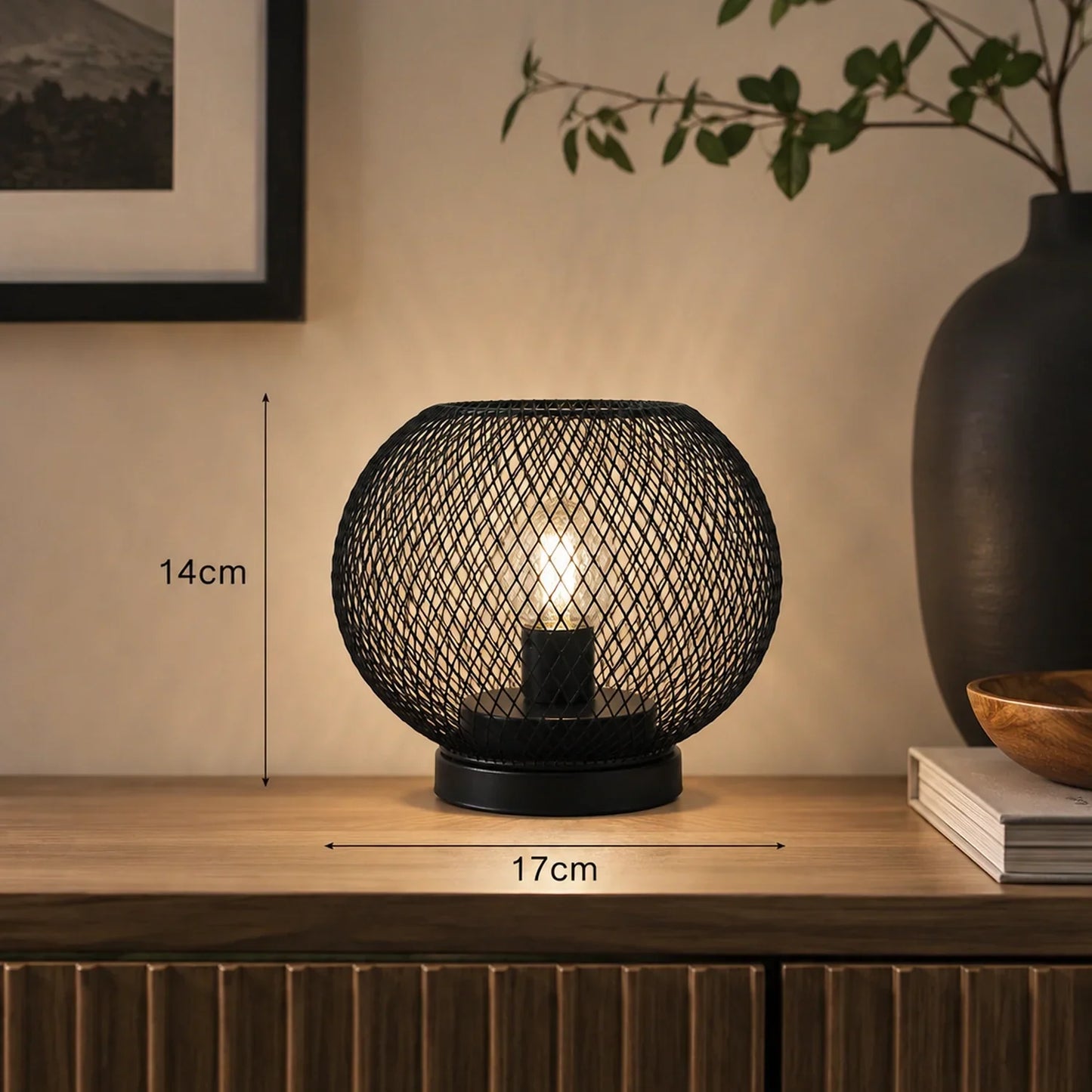 Black battery-operated LED table lamp with a spherical wire mesh design, measuring 14 cm in height and 17 cm in width, displayed on a wooden surface.