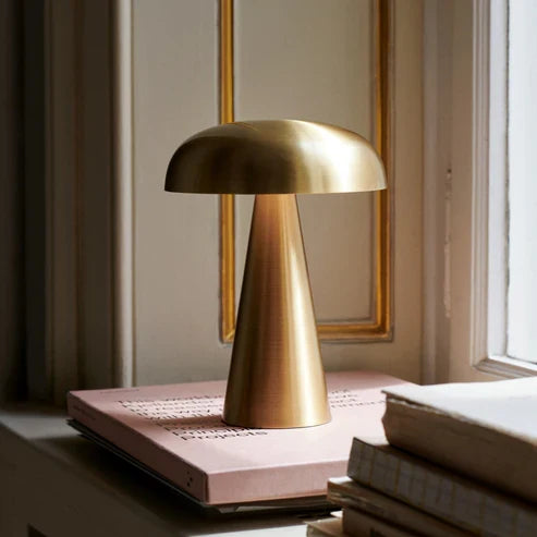 Gold battery lamp beside books
