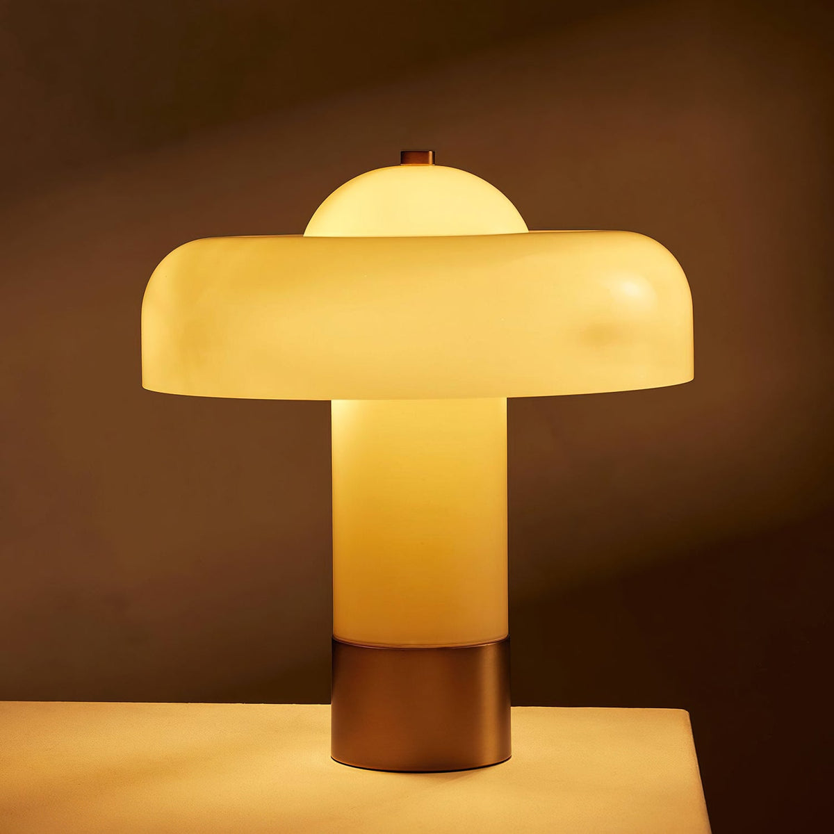 Beige glass column lamp glowing warmly