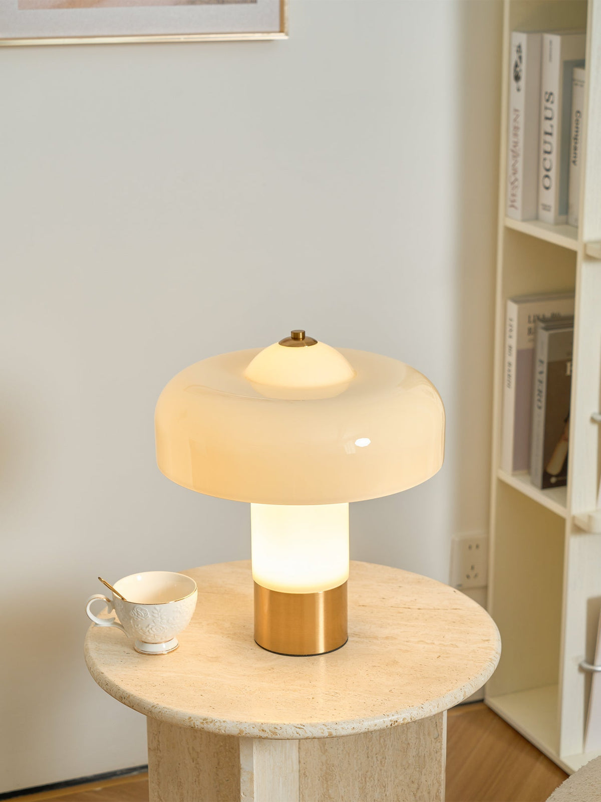 Glowing beige glass lamp beside a cup