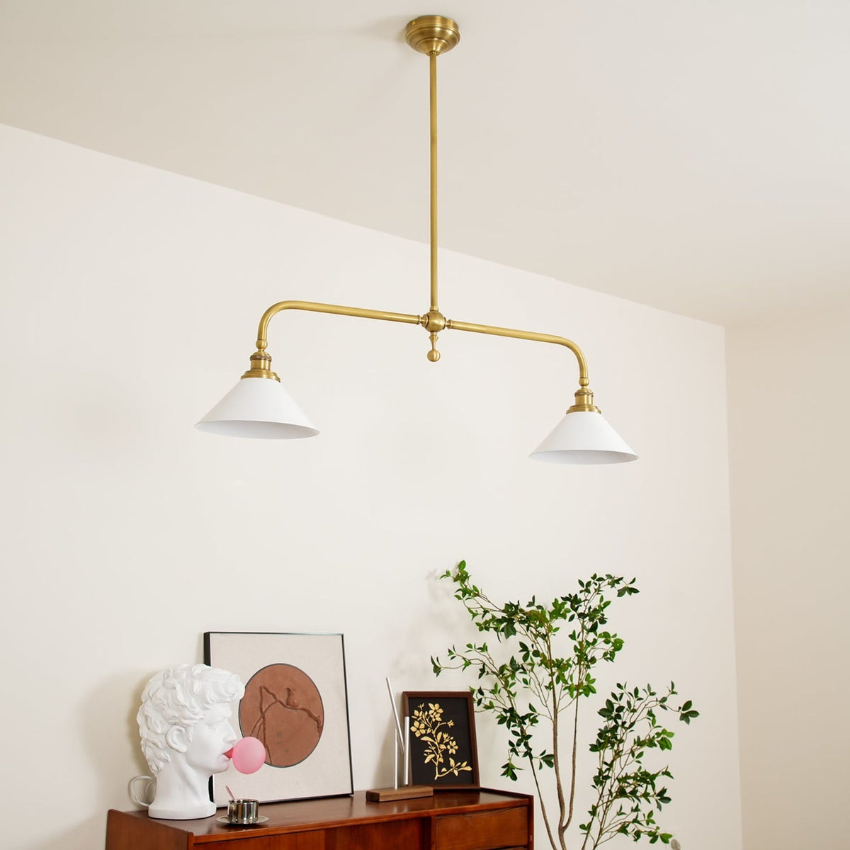 Brass ceramic pendant in a room with framed prints