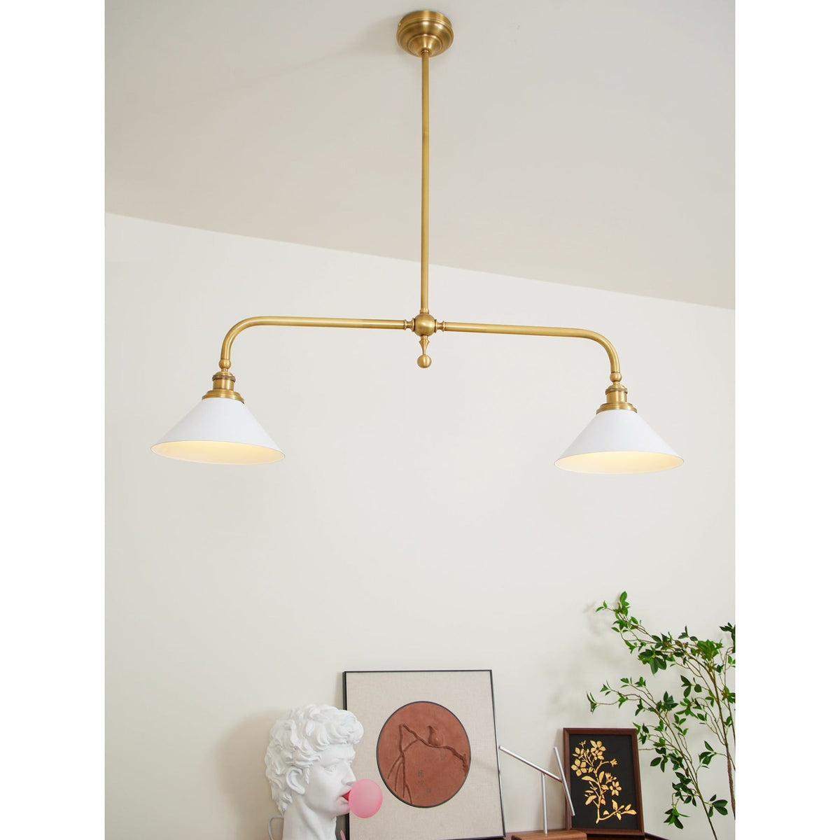 Two illuminated ceramic shades on a brass pendant