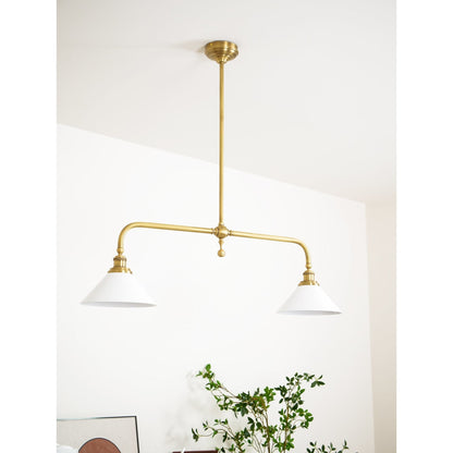 White ceramic shades beneath a curved brass frame
