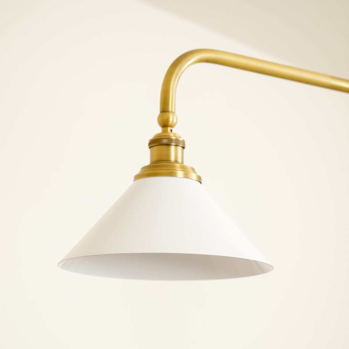 White ceramic pendant shade and curved brass arm