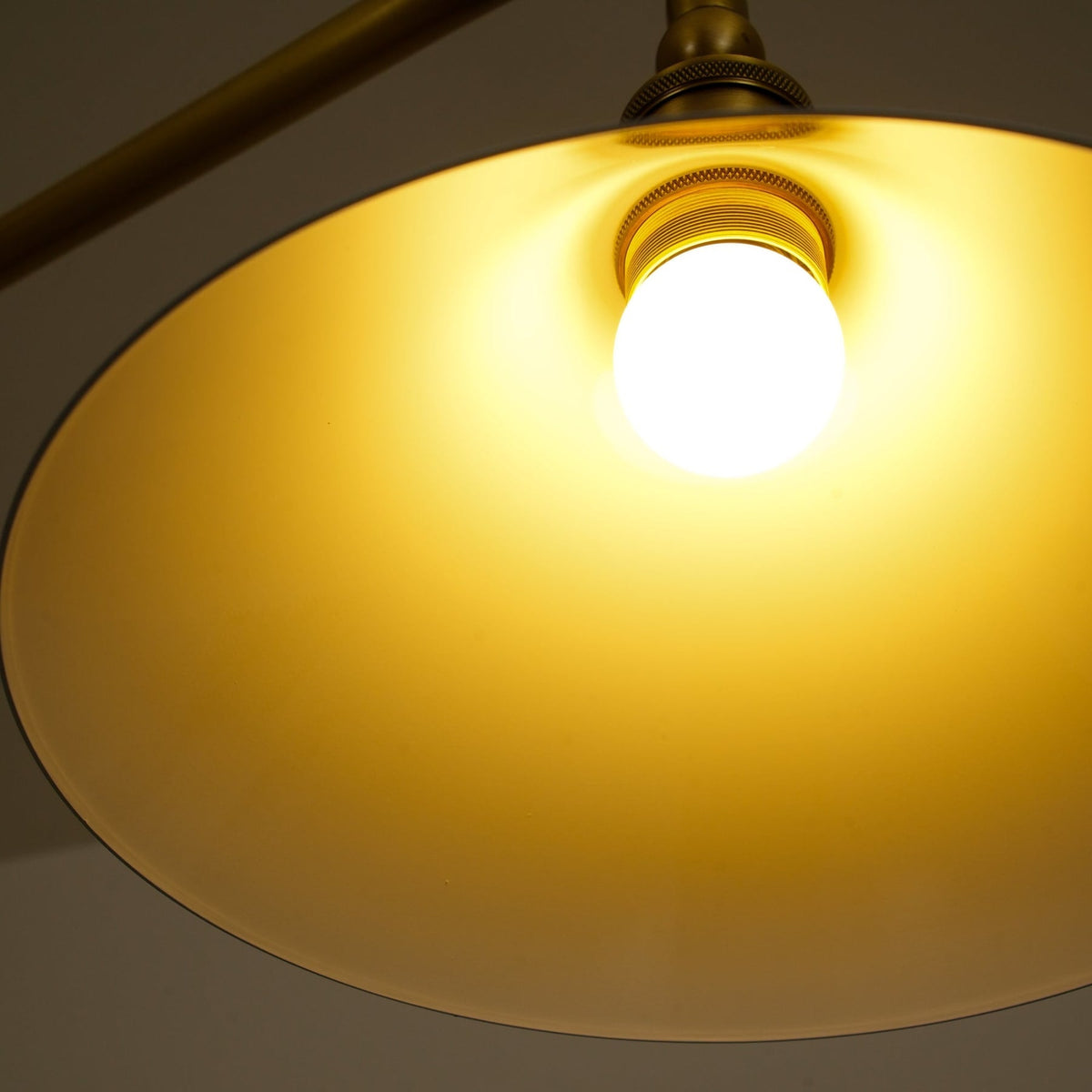Bulb illuminated inside a white ceramic pendant shade