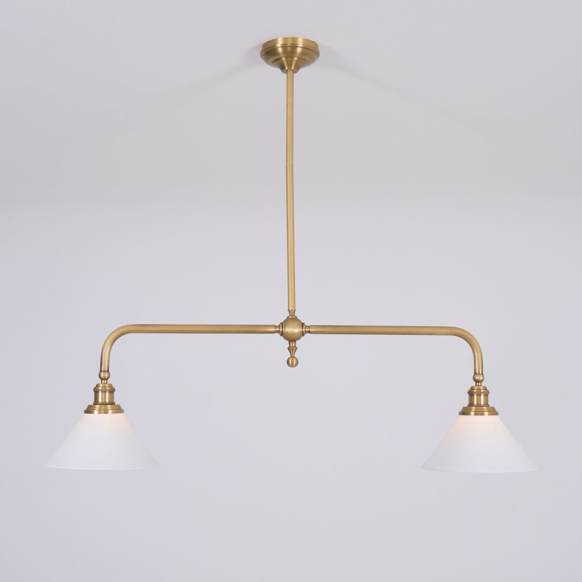 Two white ceramic shades on a brass suspension frame