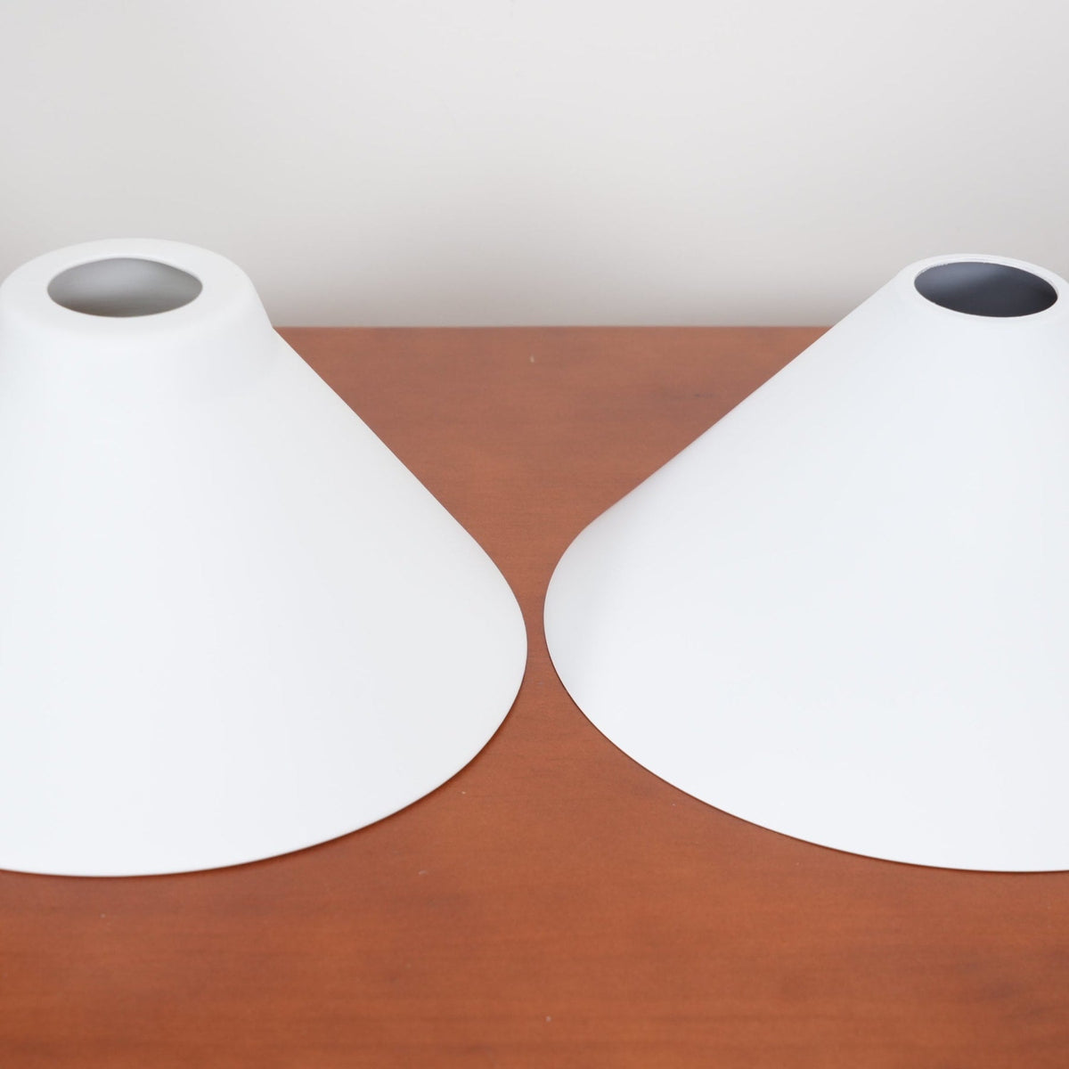 Top openings of two white ceramic shades