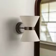 Natural linen wall light with aged bronze frame beside a mirror