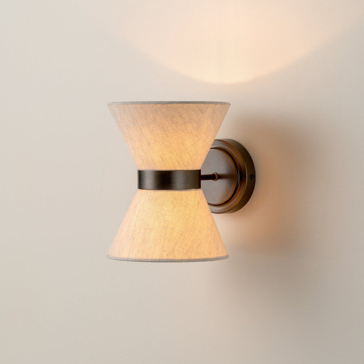 Illuminated bronze and linen wall light with an hourglass shade