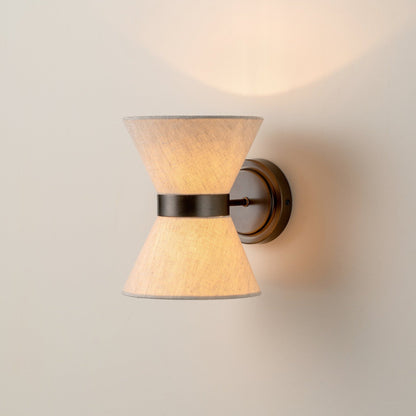 Illuminated bronze and linen wall light with an hourglass shade