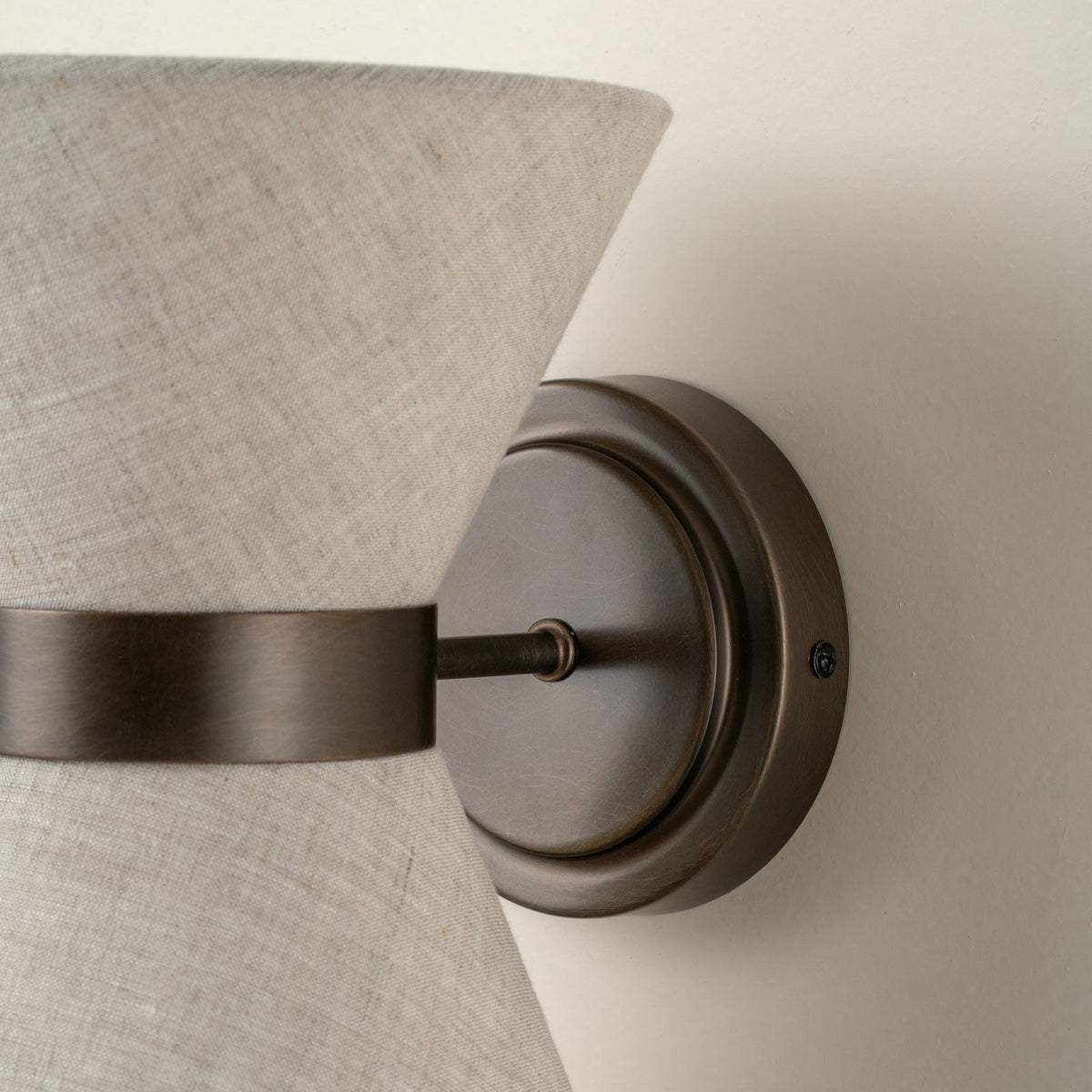 Close-up of aged bronze wall plate and linen shade