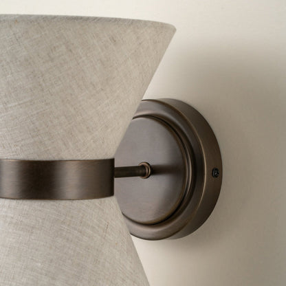 Close-up of aged bronze wall plate and linen shade