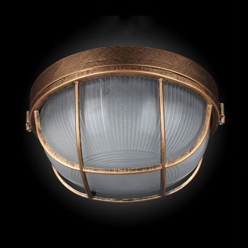 Bronze round outdoor bulkhead light with frosted glass and protective cage