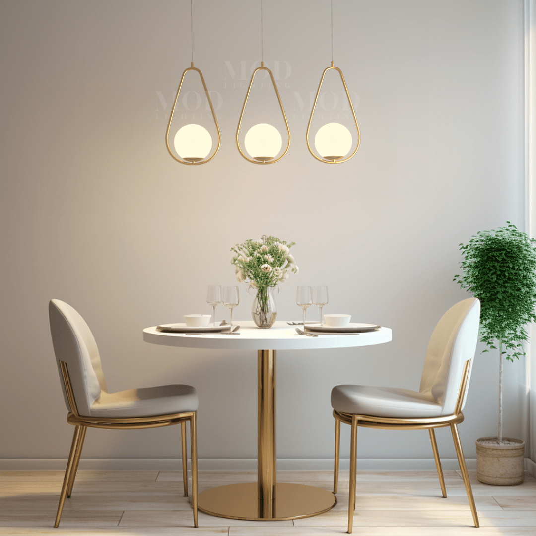 Brushed gold teardrop cage pendant lights above a round dining table