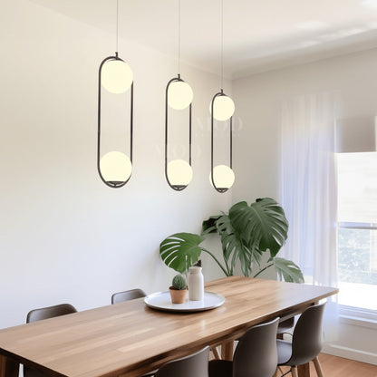 Black double-globe cage pendant lights above a dining table