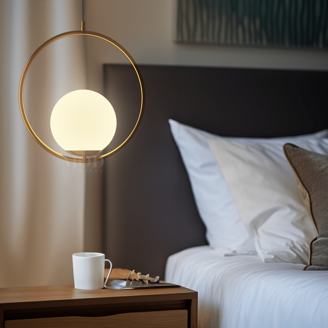 Brushed gold circular cage pendant light beside a bed