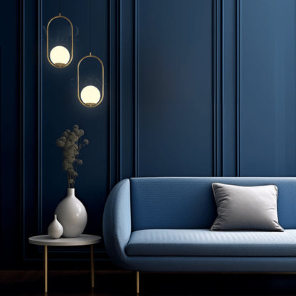 Brushed gold oval cage pendant lights beside a sofa