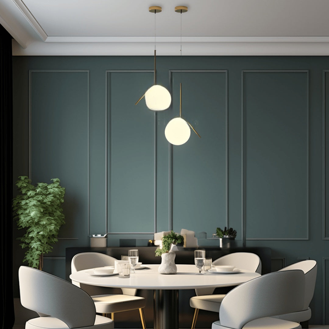 Brushed gold angled-frame pendant lights above a round table