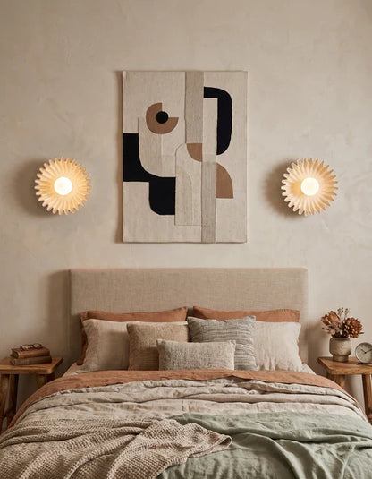 Beige ceramic flower sconces beside a bed