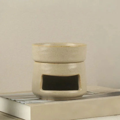 Glazed cream ceramic oil burner close-up