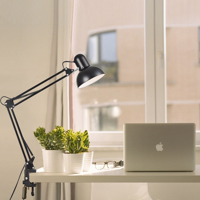 Black clamp desk lamp beside a laptop