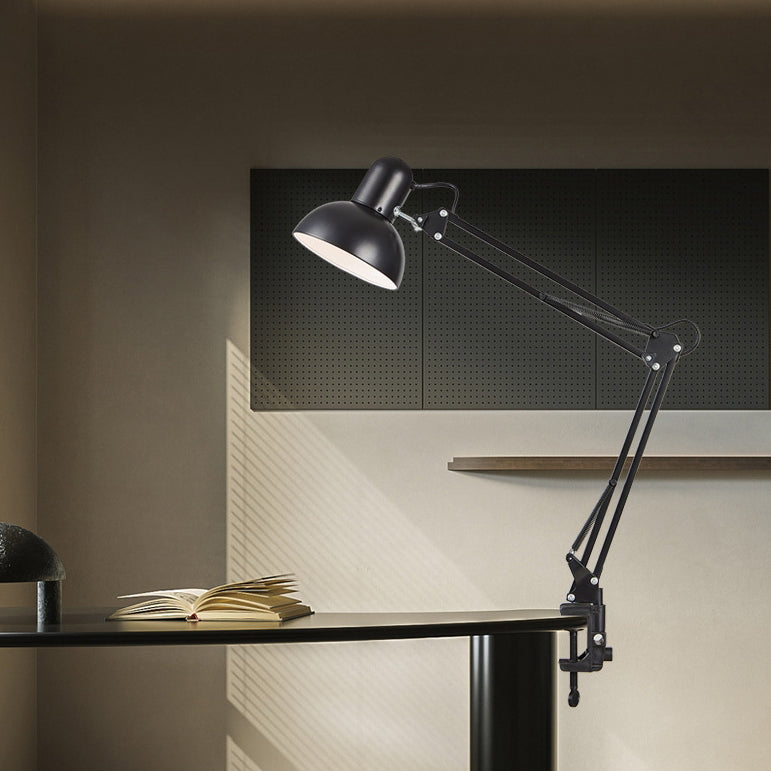 Black desk lamp attached to a worktable