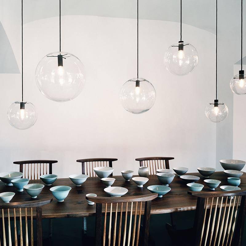 Clear glass globe pendants above a dining table