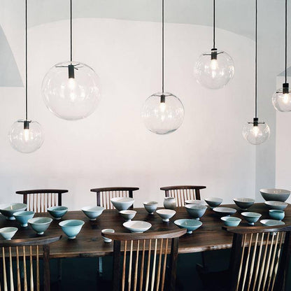 Clear glass globe pendants above a dining table