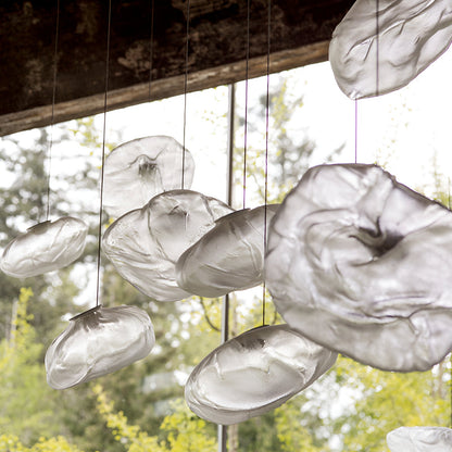 Grouped clear glass cloud pendants near a window
