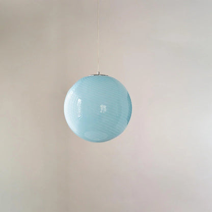 A modern spherical pendant light featuring a pale blue glass shade with a subtle white swirl pattern, suspended by a simple cord against a plain wall.