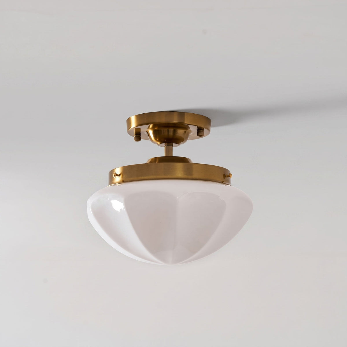 Gold compact ceiling light with a white faceted shade