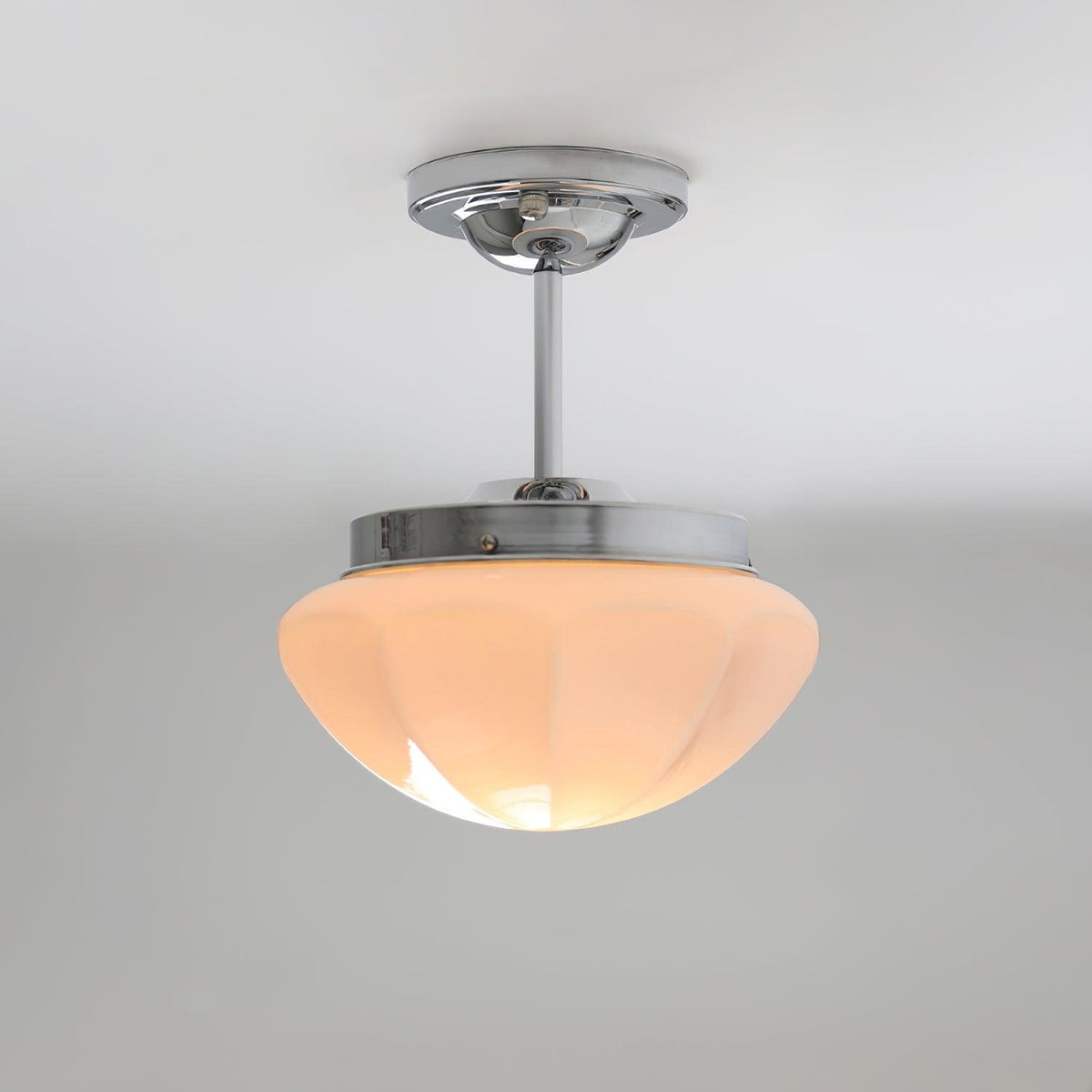 Chrome semi-flush ceiling light with a pink faceted shade