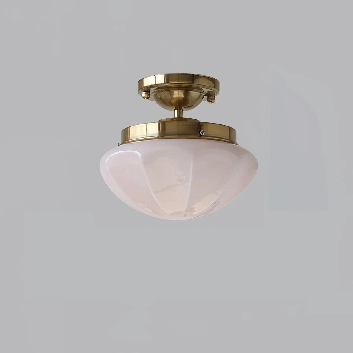 Gold compact ceiling light with a pink faceted shade