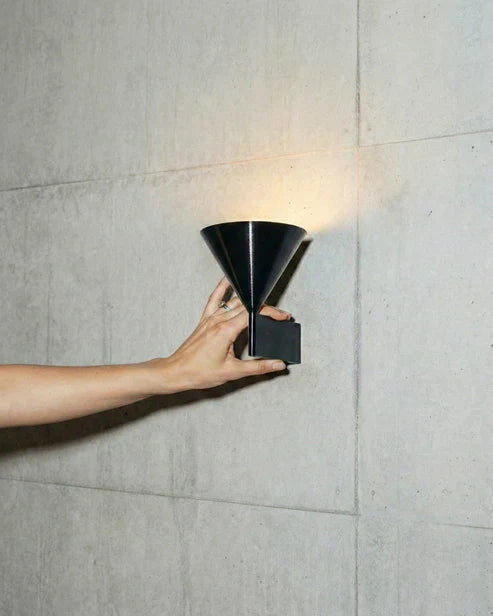 Black conical wall light mounted on a wall