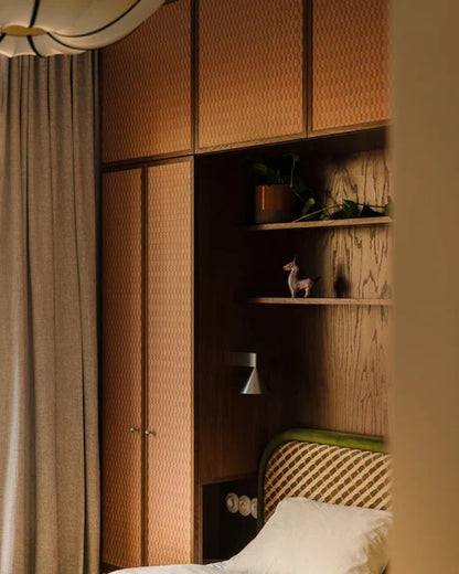 Cone wall lamp beside shelving