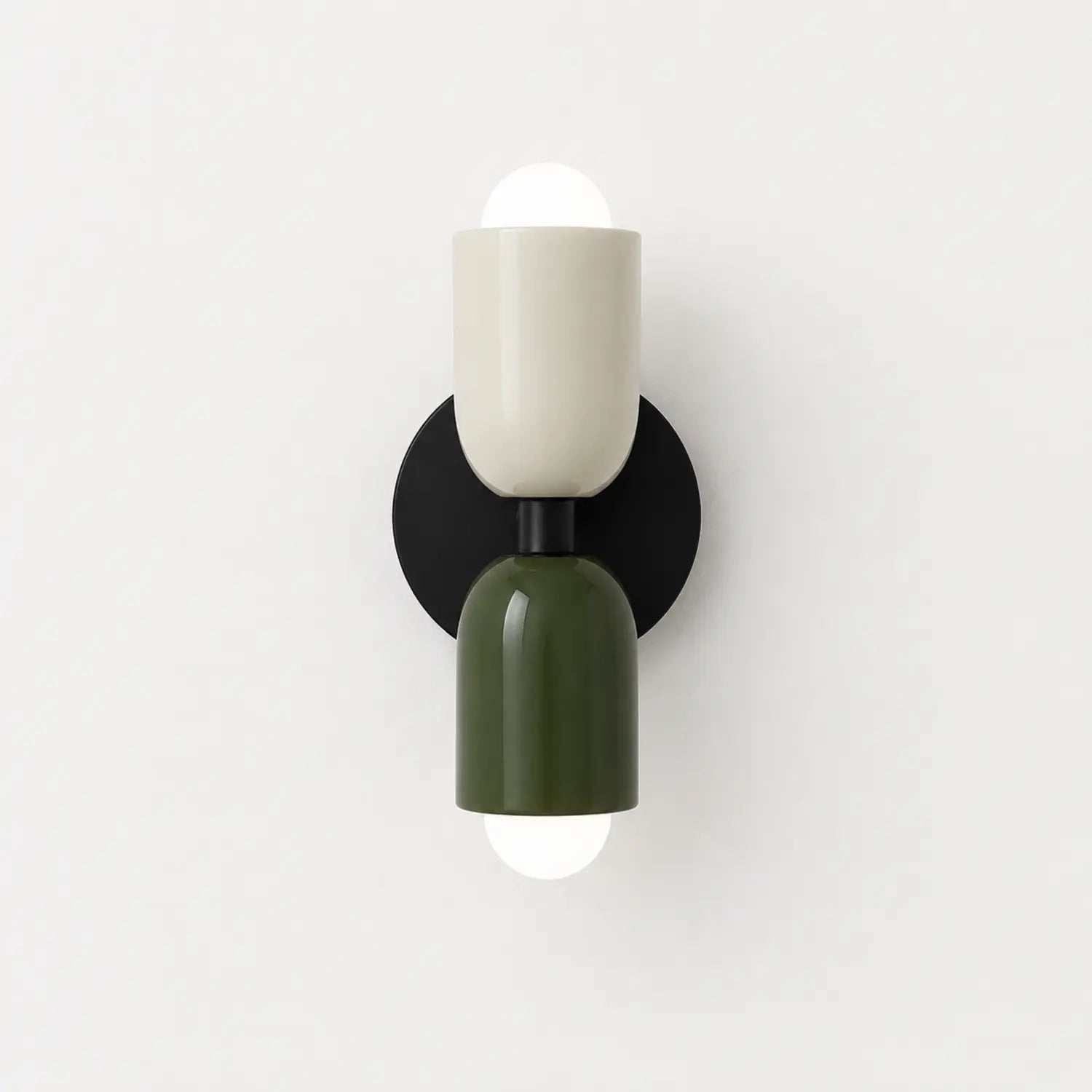 Contemporary dual-cylinder wall lamp featuring a cream and olive green finish with a black circular mount, providing up and down ambient lighting.