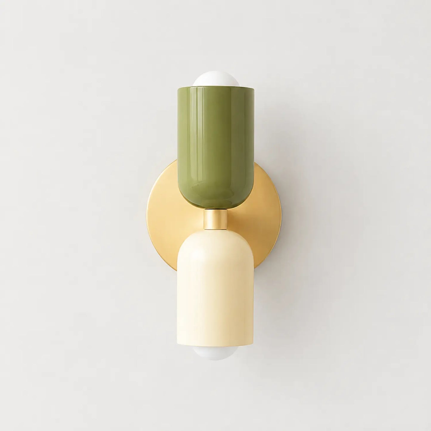 Contemporary dual-cylinder wall lamp featuring a circular gold base with one olive green and one cream cylindrical light shade in a modern design.